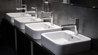 Modern sinks with mirror in public toilet.